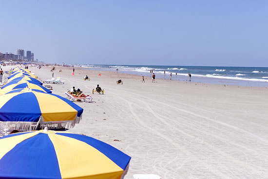 beach shoreline with people and sun umbrellas